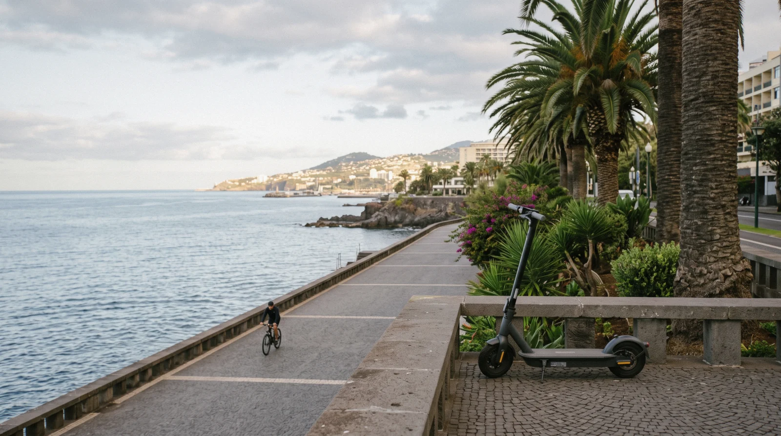 An electric scooter parked on the Funchal seafront promenade near the Lido, bike and scooter rental in Funchal