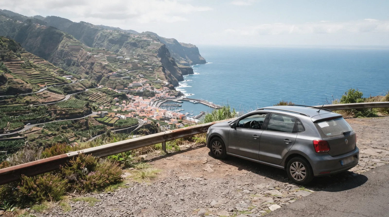 A small rental car parked on a coastal viewpoint road above Camara de Lobos near Funchal, car rental in Funchal
