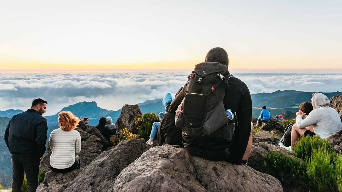 Hikers silhouetted on the PR1 ridge trail above the clouds near Pico do Arieiro on a Madeira sunrise hiking transfer in Pico do Arieiro, Madeira, from Funchal, Portugal