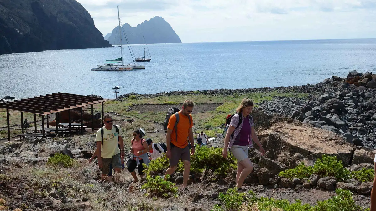 A catamaran sailing past the tall cliffs of the uninhabited Desertas Islands on a full-day catamaran trip from Funchal in Desertas Islands, Madeira