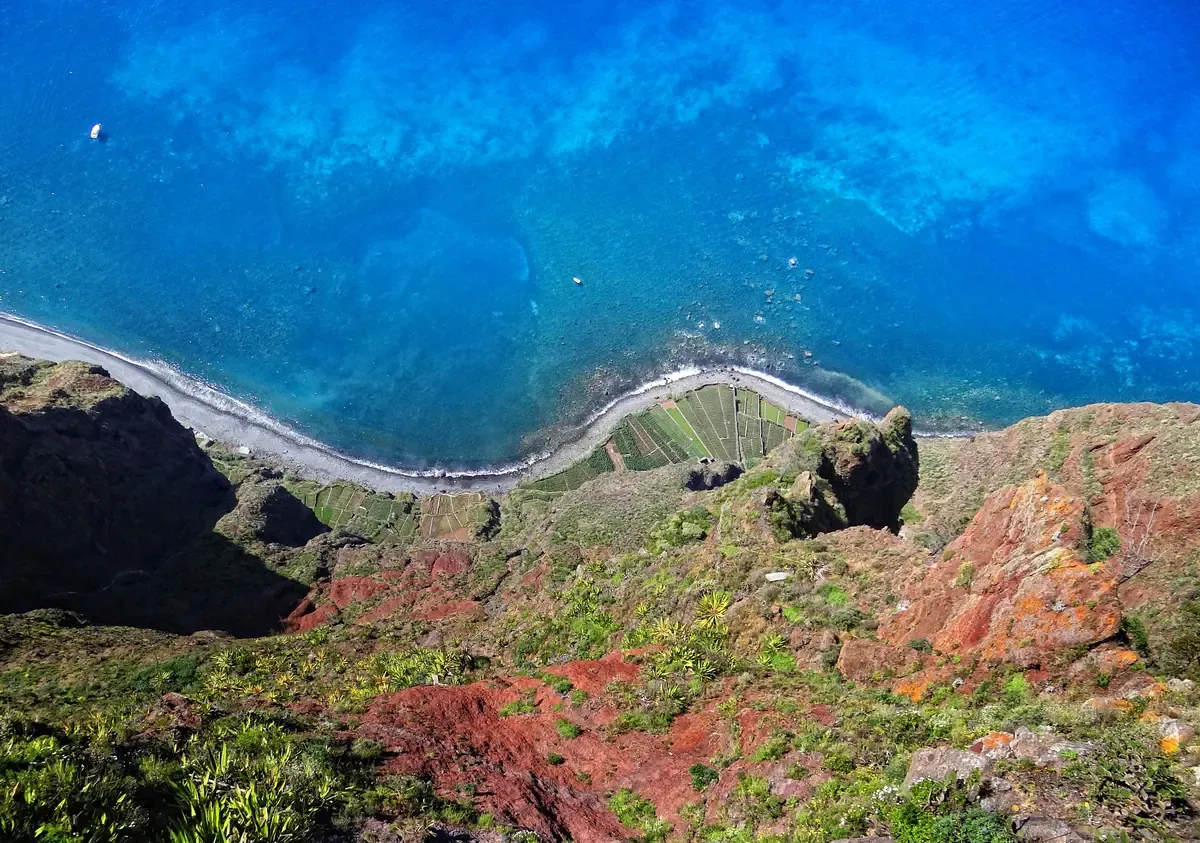 The view straight down from the Cabo Girão skywalk over terraced fields and the sea near Funchal, Madeira