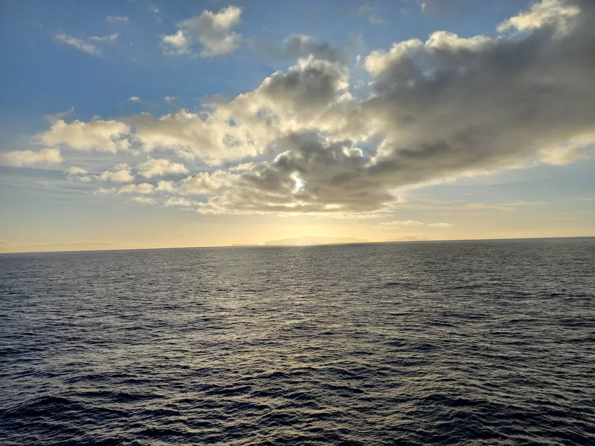 The low silhouette of the Desertas Islands on the horizon at sunset, seen from a boat sailing from Funchal, Madeira