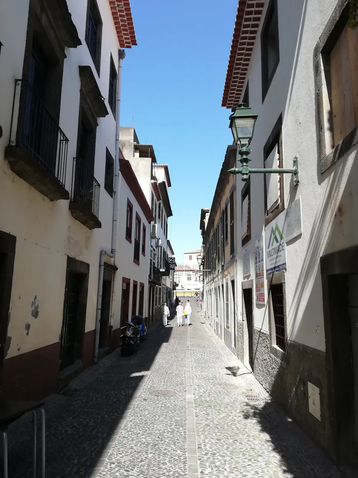 A narrow cobbled lane lined with guesthouses in the Zona Velha old town of Funchal, Portugal