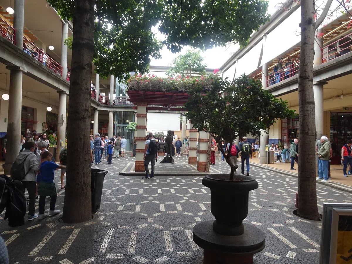 Shoppers walking through the tiled courtyard of Mercado dos Lavradores market in Funchal, Madeira, the first stop on a one day in Funchal itinerary