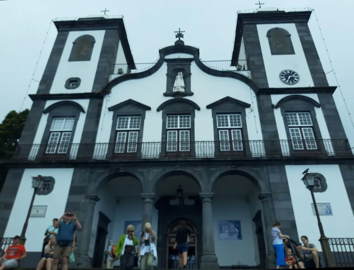 The white and black baroque facade of Monte Church viewed from the top of the stone staircase in Funchal, Madeira, Portugal